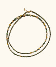 Load image into Gallery viewer, The Solstice Wrap necklace combines soft with edgy and can be worn long or wrapped. The asymmetric pattern is playful and combines the good vibrations of; intuition in pink moonstone, calm in pyrite, self-love in emerald, protection in golden eye and luck in pearl. Named after Solstice, which means ‘the day the sun stands still’. In summer this is the longest day, in winter the shortest day.
