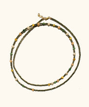 Load image into Gallery viewer, The Solstice Wrap necklace combines soft with edgy and can be worn long or wrapped. The asymmetric pattern is playful and combines the good vibrations of; intuition in pink moonstone, calm in pyrite, self-love in emerald, protection in golden eye and luck in pearl. Named after Solstice, which means ‘the day the sun stands still’. In summer this is the longest day, in winter the shortest day.