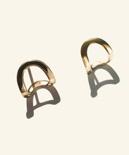 Load image into Gallery viewer, Hand made and fluid in shape, these fine golden earrings wraps around the lobe like a golden harness, exaggerating its curve.
