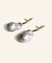 Load image into Gallery viewer, Suspended from an elongated vertical gold bar hangs an unruly pearl. Lustrous and perfectly imperfect, the unique distinctiveness of baroque pearls is a beautiful reminder that we ourselves are just that.   Named after the Queen Boudicca, who found the warrior within and created her own legend..     Made from juicy natural white baroque pearls   the slim elegant fitting is 18 ct gold plated silver. Each pearl is unique. Handmade. Bassike.
