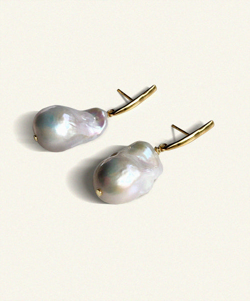 Suspended from an elongated vertical gold bar hangs an unruly pearl. Lustrous and perfectly imperfect, the unique distinctiveness of baroque pearls is a beautiful reminder that we ourselves are just that.   Named after the Queen Boudicca, who found the warrior within and created her own legend..     Made from juicy natural white baroque pearls   the slim elegant fitting is 18 ct gold plated silver. Each pearl is unique. Handmade. Bassike.