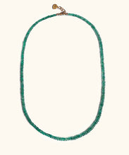 Load image into Gallery viewer, A emerald necklace on white background. With gold lock and chain. The emerald is ruled by Venus, the Goddess of love and beauty, while green activates the heart Chakra. This necklace is the the ultimate confession of self love. 
