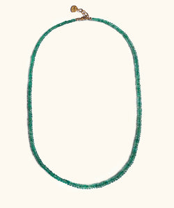 A emerald necklace on white background. With gold lock and chain. The emerald is ruled by Venus, the Goddess of love and beauty, while green activates the heart Chakra. This necklace is the the ultimate confession of self love. 
