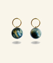 Load image into Gallery viewer, Suspended from an elegant golden circle, the Golden Eye orb shimmers with a silky lustre. A beautiful chatoyant stone with deep bands in blue and gold, these earrings are quietly powerful.
