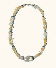 Load image into Gallery viewer, The gleaming white baroque pearl is held in place by a row of sunny Citrine. A necklace strung with light yellow citrine chips. Each 4 cm there is a small white pearl and a black facetted bead. At the bottom of the necklace there is a white organic shaped baroque pearl.
