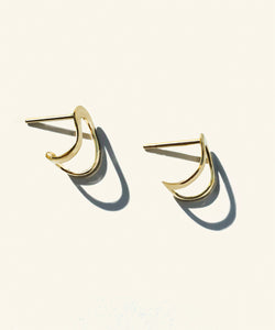 Hand made and fluid in shape, these fine golden earrings wraps around the lobe like a golden harness, exaggerating its curve. Handmade in Australia