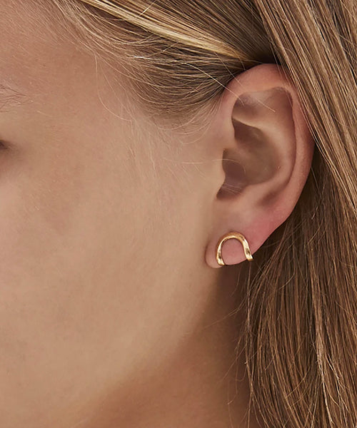 Hand made and fluid in shape, these fine golden earrings wraps around the lobe like a golden harness, exaggerating its curve. Made in Australia