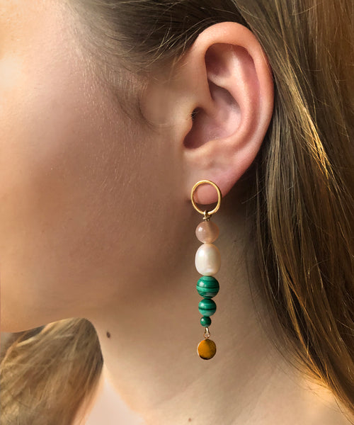 SOLSTICE ASYMMETRIC EARRINGS With its remarkable green colour and distinctive concentric  rings, malachite has a regal and mesmerising appearance.   Orbs of green malachite, pink moonstone and white pearl  make up the Solstice Asymmetric Earrings, creating a fresh  colourful expression for summer.
